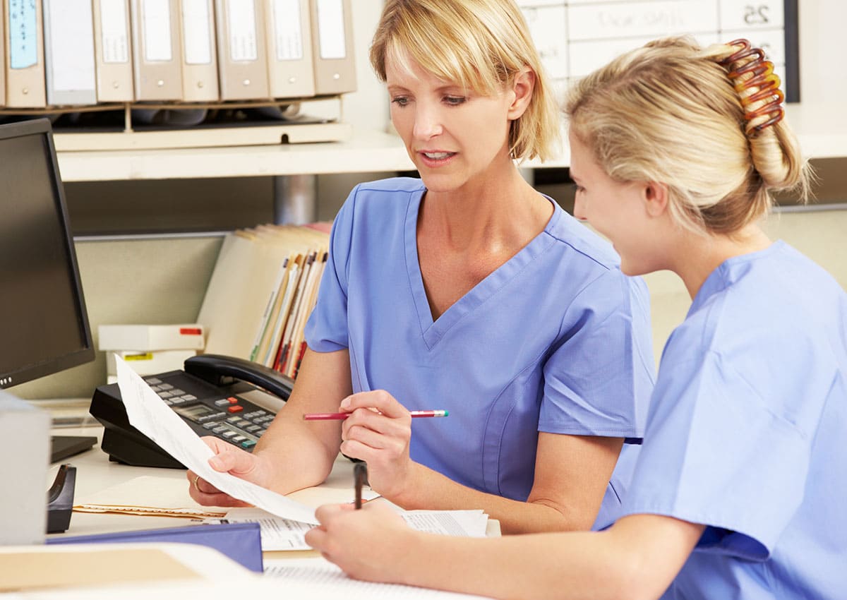 two nurses working at nurses station