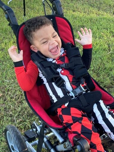 Pediatric homecare patient laughing in a red stroller