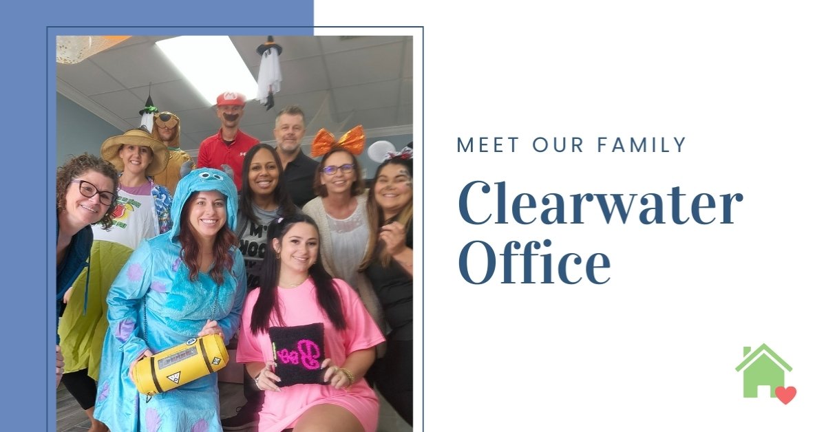 Ten people in an office pose in Halloween costumes