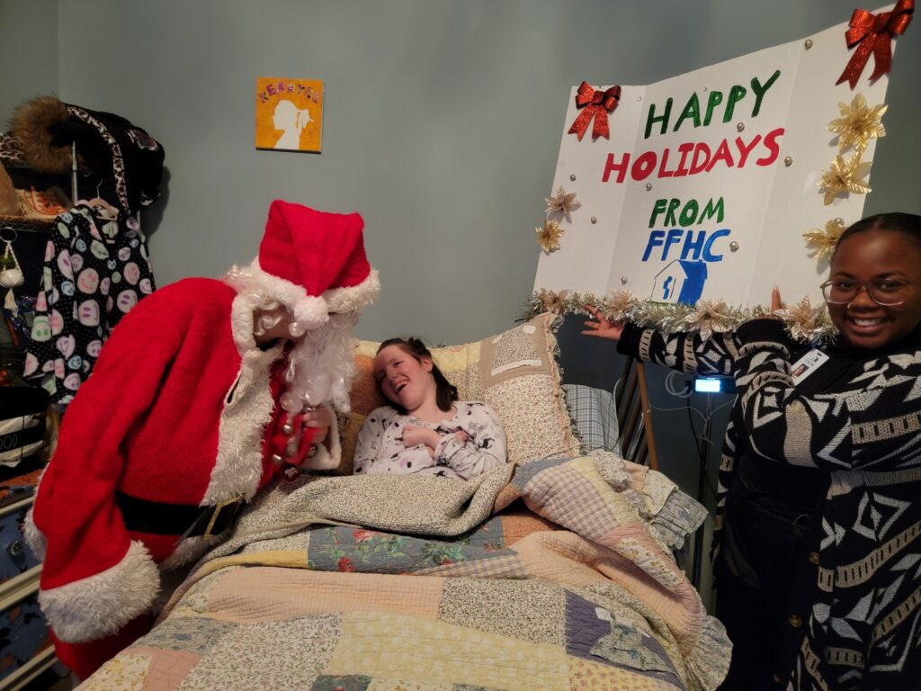 Santa visiting a pediatric homecare patient who is laying in bed