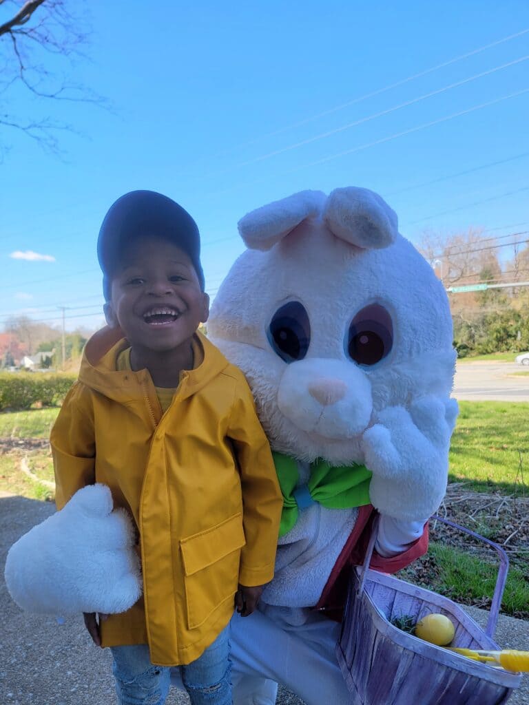 A pediatric homecare patient smiling next to the easter bunny