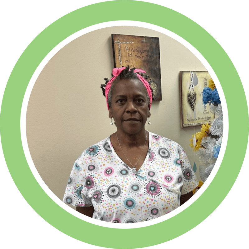 Woman in colorful scrubs smiles at the camera