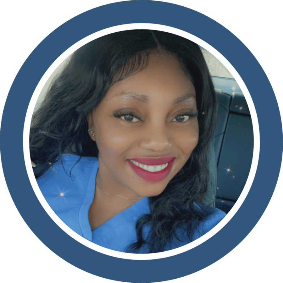 Woman in blue scrubs smiles at the camera