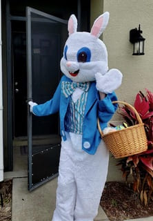 The Easter Bunny waving and opening a door