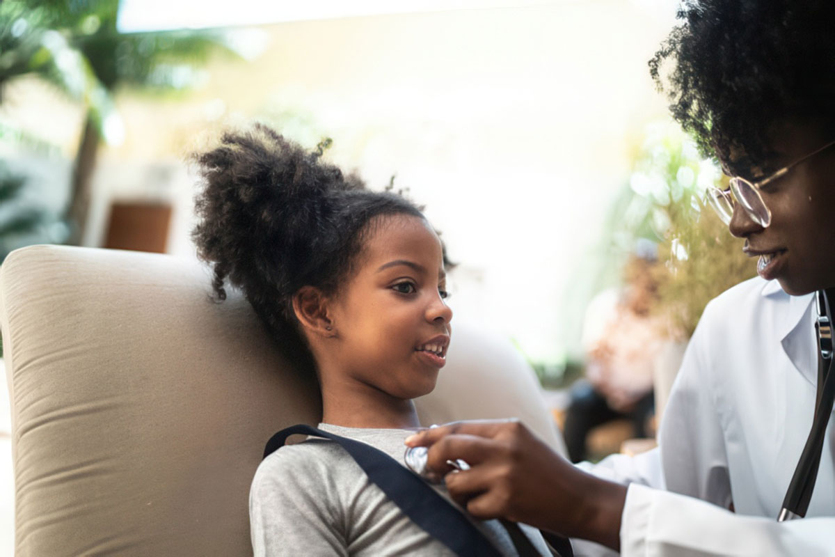 Doctor listening to little girl's heart